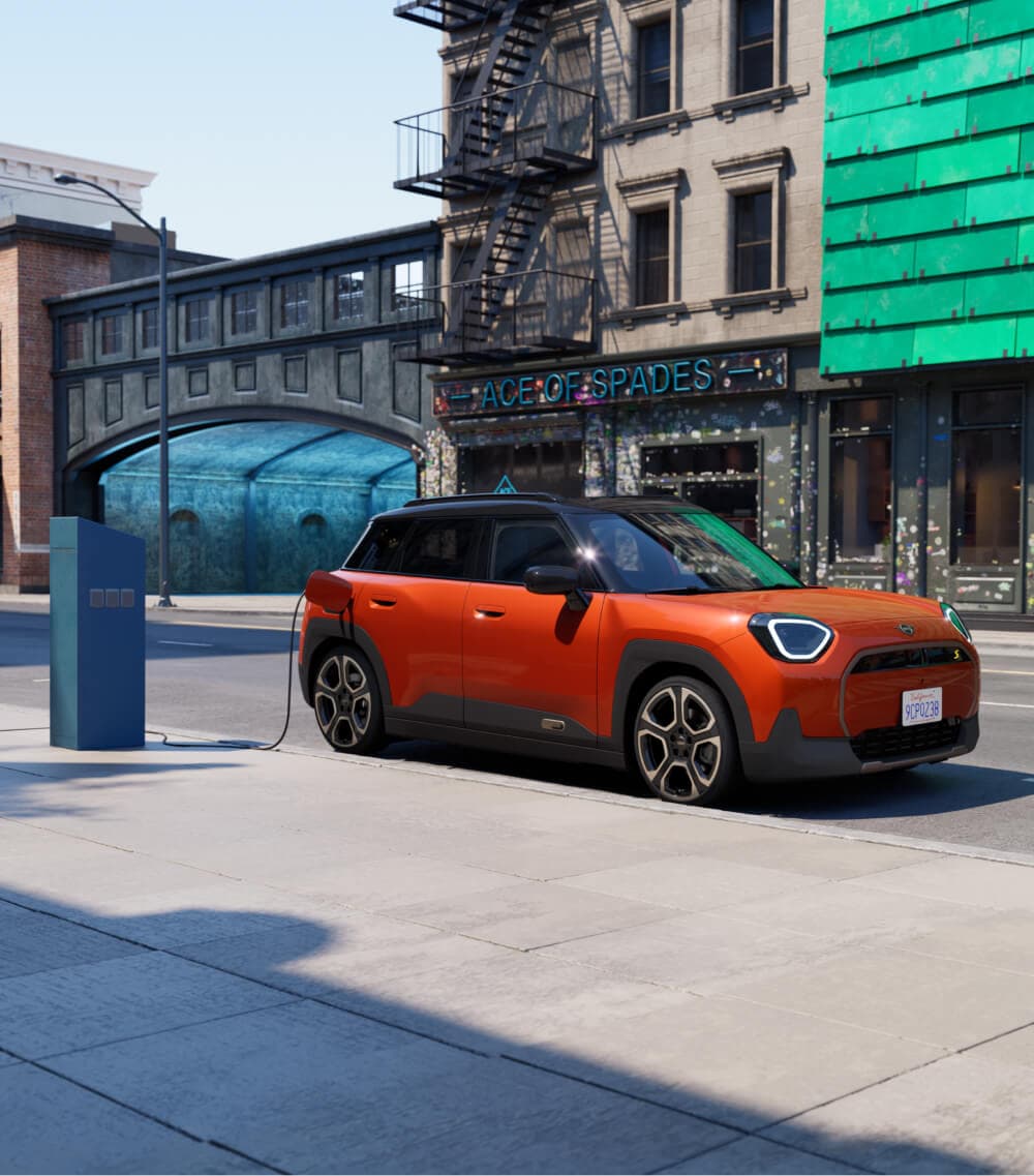 Side angled view of MINI Aceman charging outside street