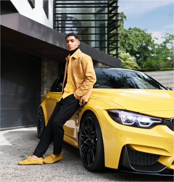 Man leaning against a yellow BMW