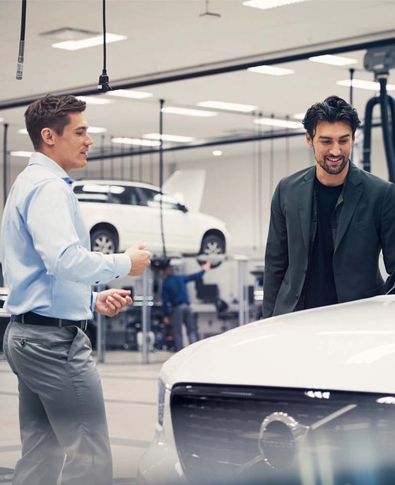 Salesman and customer interacting with Volvo vehicle